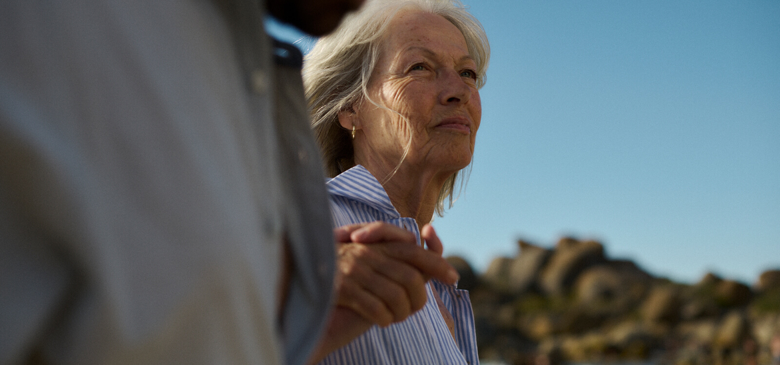 Mujer en la playa sonriéndo mientras que da una vuelta Mujer en la playa sonriéndo mientras que da una vuelta